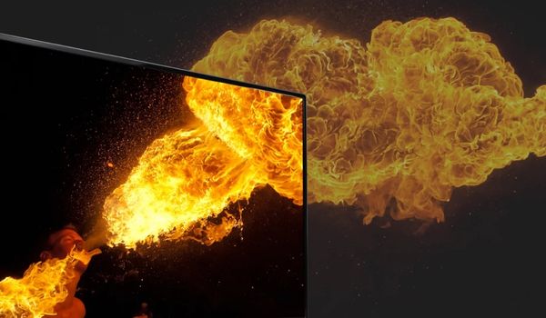Gros plan sur un écran de téléviseur affichant une explosion de flammes dorées avec débordement visuel hors cadre