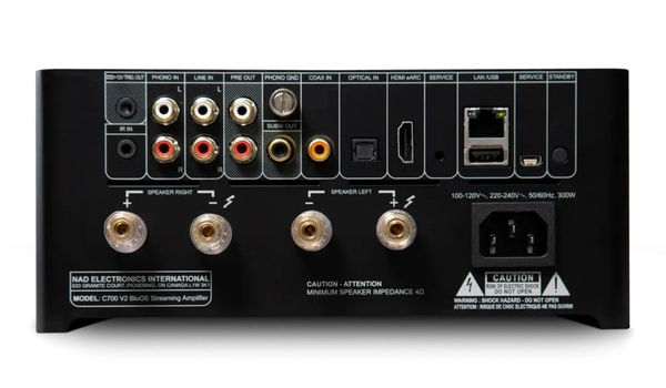 Face arrière du NAD C 700 V2 avec entrées phono, ligne, HDMI eARC et sorties enceintes sur fond blanc.