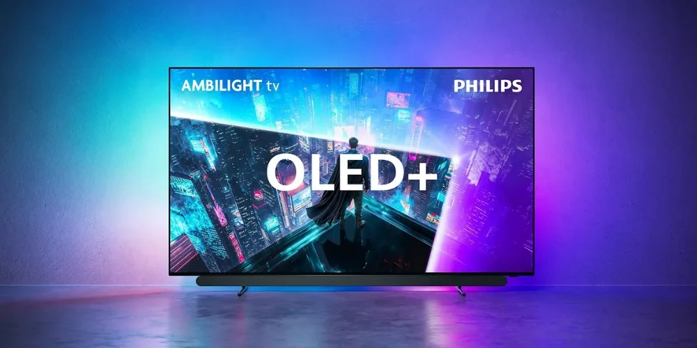 Philips 48OLED911 posé devant un mur, halo Ambilight bleu et violet autour de l'écran OLED+ et barre audio dessous