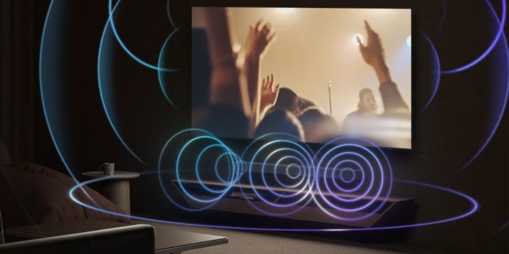 Samsung TMR75R95H en situation soirée cinéma, schéma de diffusion sonore 4.2.2 canaux OTS+ avec ondes concentriques bleues et violettes représentant les haut-parleurs frontaux et le caisson de basses
