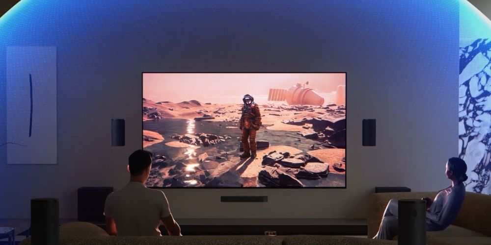 Sony BRAVIA Theatre Trio installé sous un téléviseur, tours avant de part et d'autre de l'écran