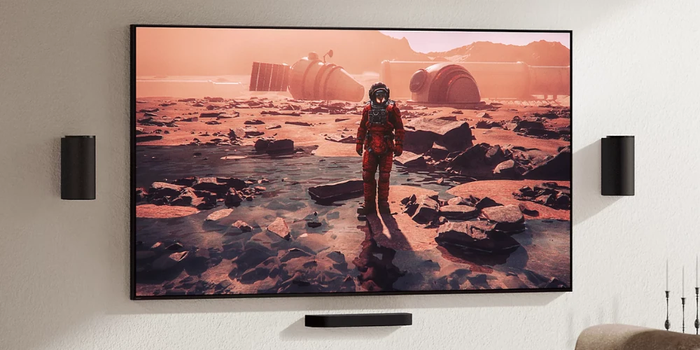Téléviseur mural avec astronaute sur Mars, enceintes Rear Sony de chaque côté et barre Trio en dessous