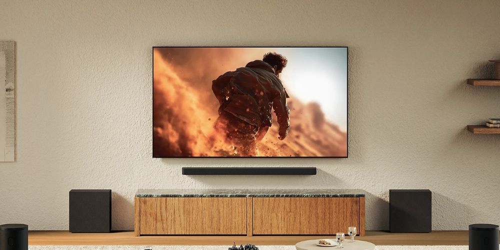 Pack Sony HT-A9000 et deux caissons SA-SW8 installés dans un salon, barre fixée sous un téléviseur BRAVIA diffusant un film d'action, deux caissons posés de part et d'autre du meuble TV