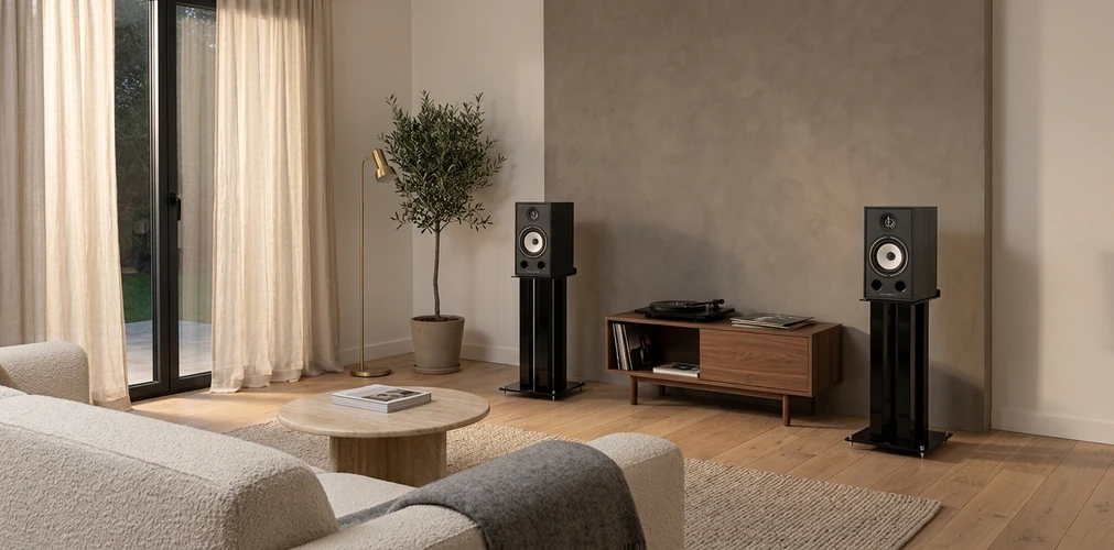 Paire de supports Triangle S03 noirs avec enceintes Borea, de part et d’autre d’un meuble en noyer avec platine vinyle
