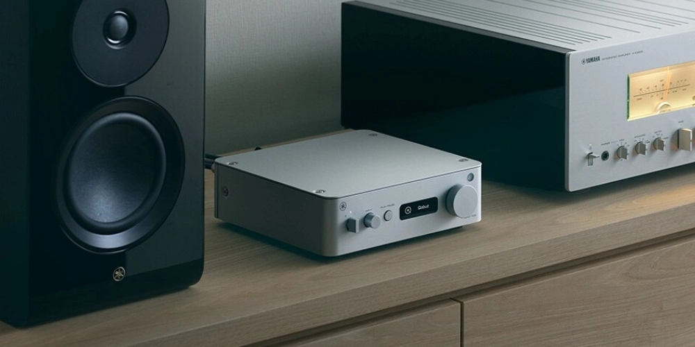 Yamaha WXC-70A en finition argent devant un ampli intégré Yamaha vintage argenté, à côté d'une enceinte bibliothèque