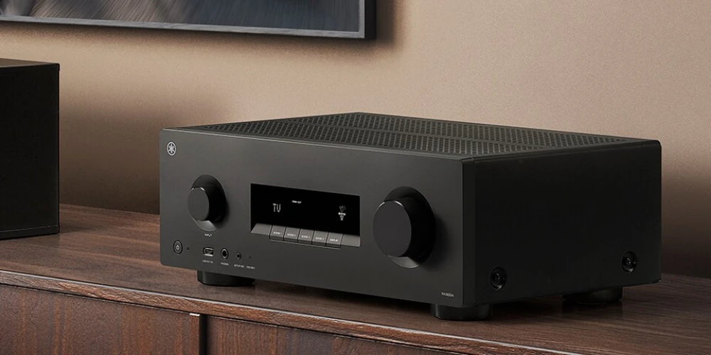 Yamaha RX500A noir posé sur un meuble en bois, à côté d'une enceinte colonne dans un salon